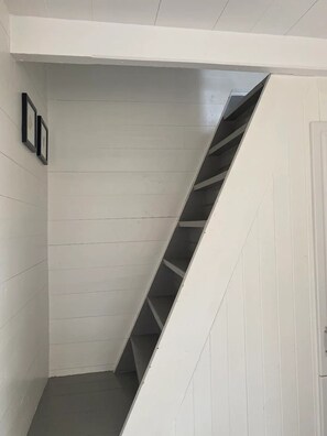 A white interior with a diagonal staircase leading to a lower level.
