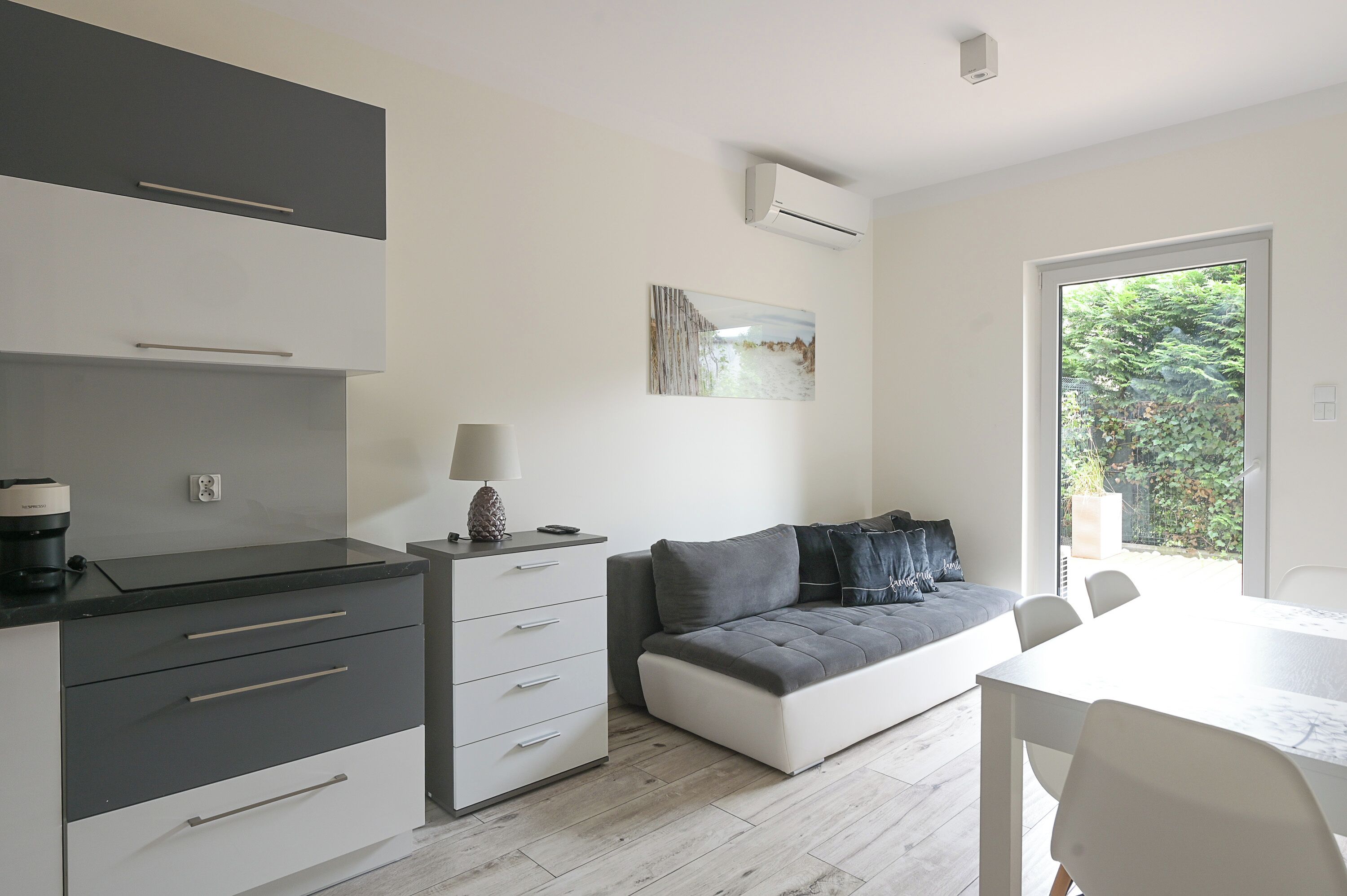 Una cocina moderna con zona de comedor, sofá y un amplio ventanal.