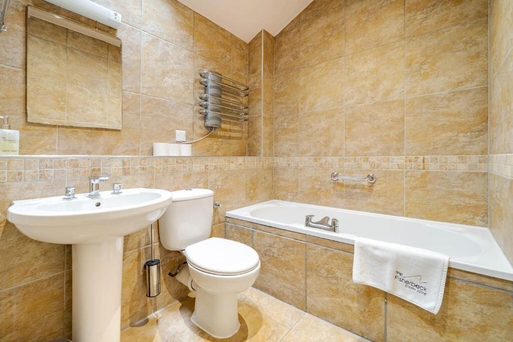 A bathroom with a sink, toilet, and bathtub.