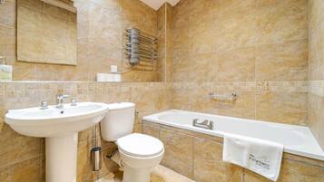 A bathroom with a sink, toilet, and bathtub.