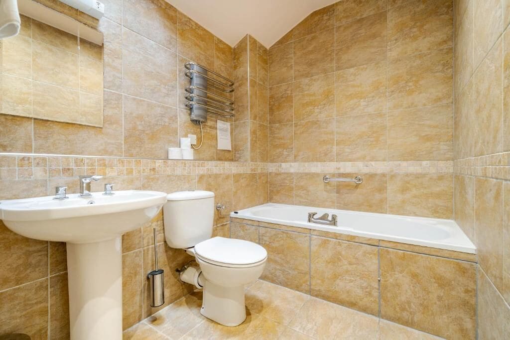 A bathroom with a sink, toilet, and bathtub.