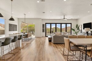 Una cocina moderna con barra, comedor y un amplio ventanal con vistas al desierto.