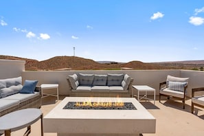 A rooftop terrace with a fire pit, outdoor furniture, and a view of the landscape. - St. George Oasis 7 Bedroom Home (Washington)
