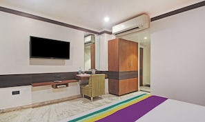 Un baño moderno con piso de mármol, un tocador con espejo, un televisor y un armario.