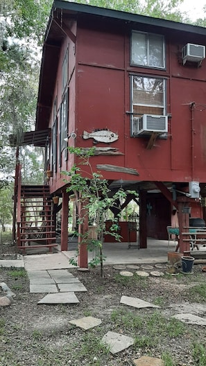 Een rood gebouw met een visdecoratie, terrasplekken en een trap naar een terras.
