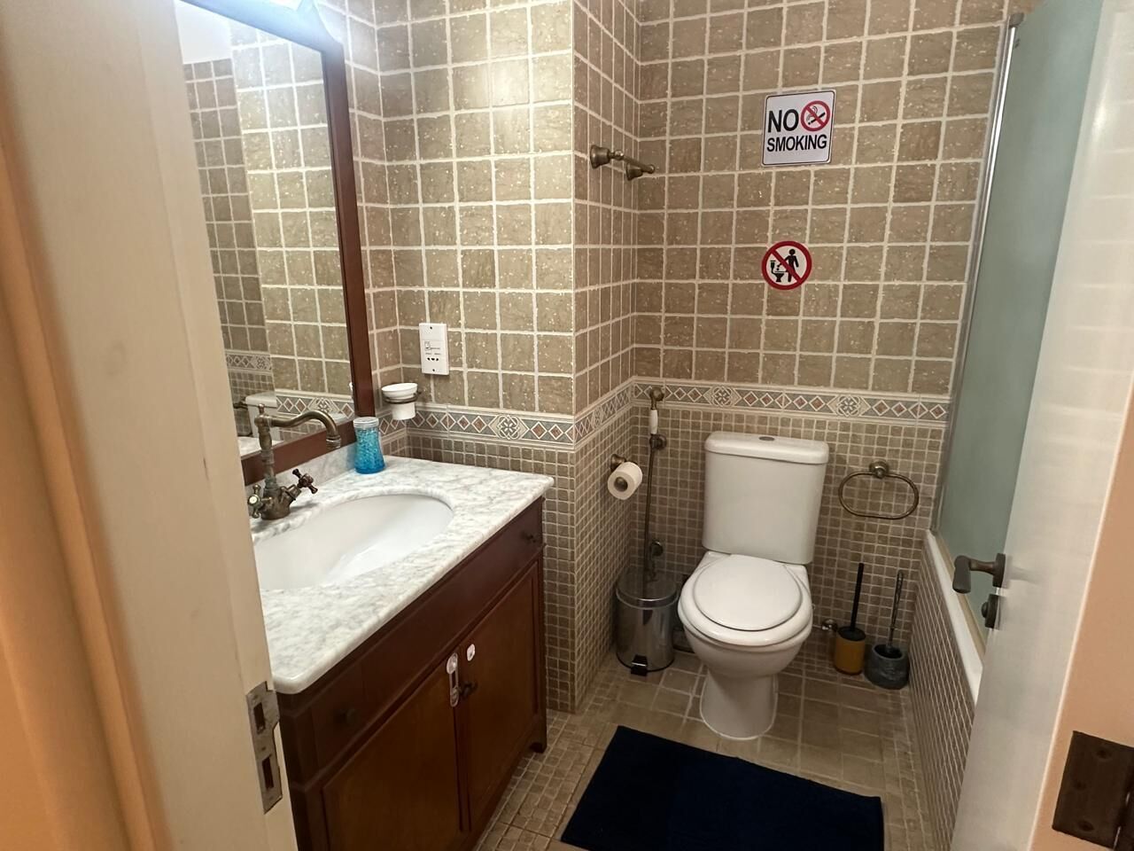 A bathroom with a sink, toilet, and shower area.