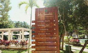 A wooden sign with amenities including courts, gym, coworking, pools, club house, fire pit, playground, and pet zone. - Modern Jungle Escape - Selva Escondida 2
Family sized condo with pool and gym (Puerto Morelos)