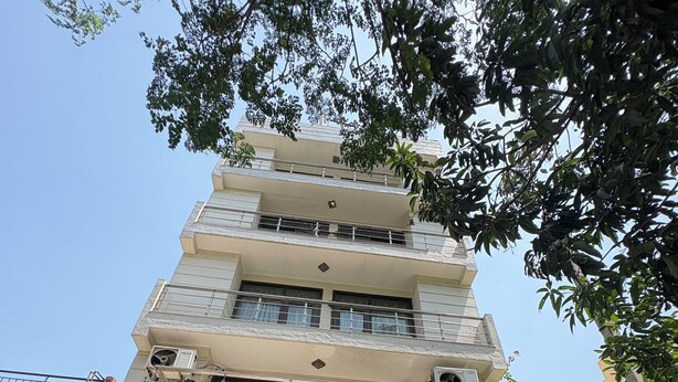A multi-story building with balconies, a gated entrance, and a clear sky. - Staylo Jaggannath Stays (New Delhi)