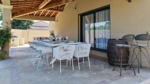 An outdoor patio with a wooden ceiling, a table set for dining, and a barrel. - 12-Person Villa A/C Heated Pool office close Aix Provence (Salon-de-Provence)