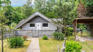 Una casa con fachada gris, una puerta principal y un porche pequeño.