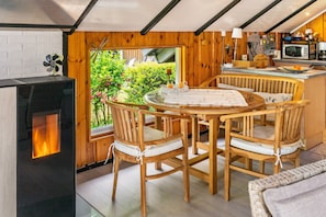 Ein gemütliches Holzinterieur mit Esstisch, Stühlen, Kamin und Küchenzeile.