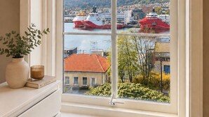 Una finestra con vista su un fiume, barche e palazzi.