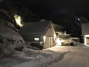 Un paysage enneigé avec une maison et un immeuble doté d’un balcon.