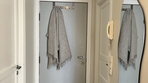 A hallway with a door, a mirror, and a telephone. - Central apartment close to Bryggen (Bergen)