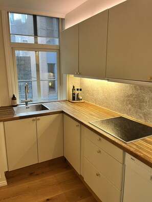 Eine moderne Küche mit eingebautem Spülbecken, Holz Arbeitsplatte und weißen Schränken.
