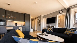 A modern living room with a sofa, coffee table, and a flat-screen TV. - Golsfjellet Apartment with Sauna (Gol)