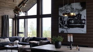 A modern living room with a sofa, coffee table, and a dining area with candles.