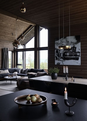 Una sala de estar moderna con un sofá, una mesa de centro y un comedor con velas.