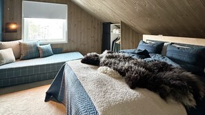 Un dormitorio con cama, ventana, banco empotrado y armario.