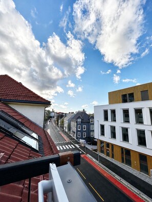 Une vue de rue avec des bâtiments, un ciel dégagé et un passage piéton.