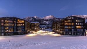Ett modernt hotell med flera våningar, stora fönster och en central innergård.