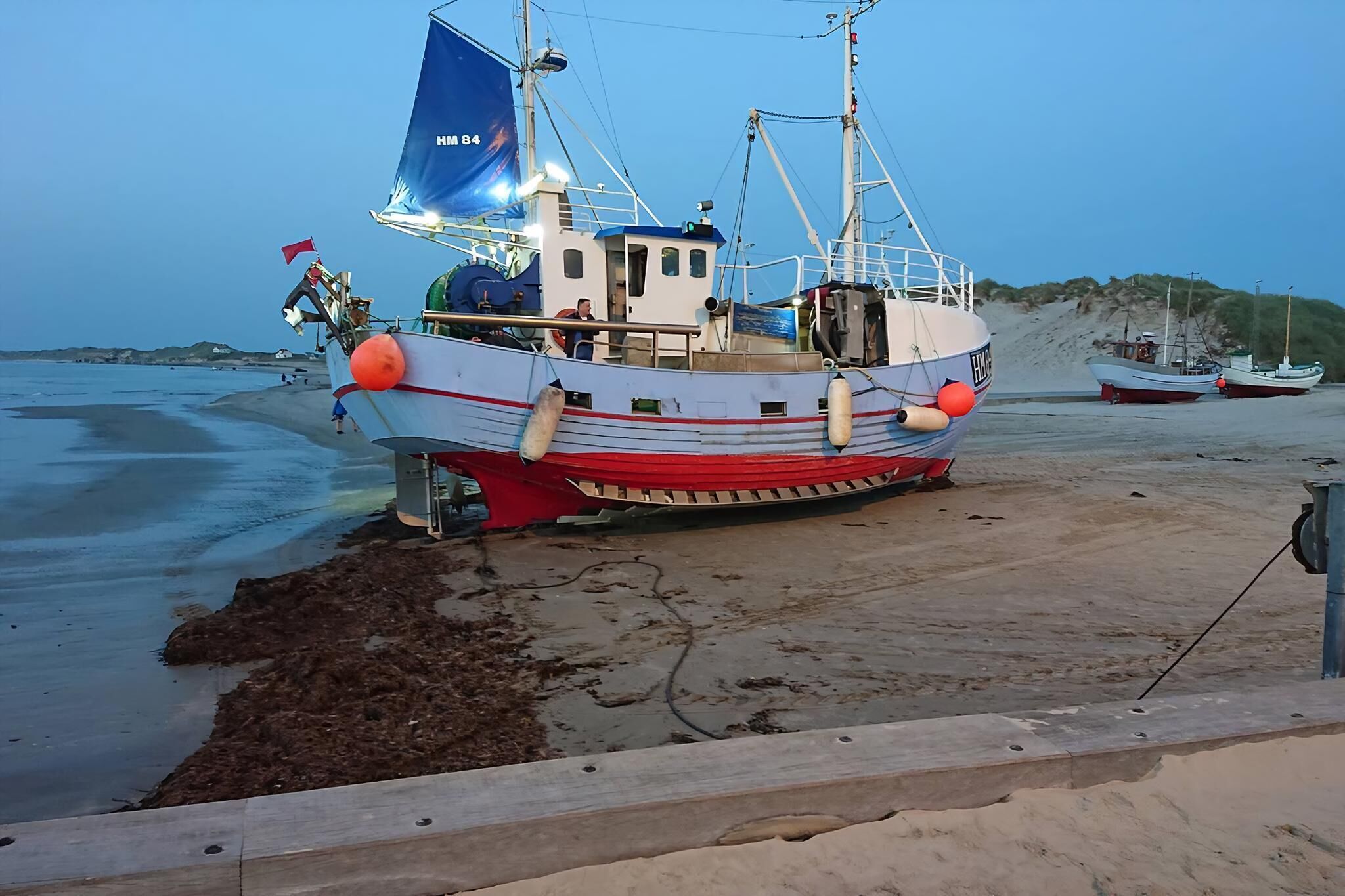 Un bote amarrado en una playa arenosa bajo un cielo despejado.