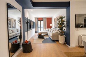 Een moderne woonkamer met een bank, salontafel en decoratieve objecten.