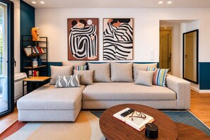 Ein modernes Wohnzimmer mit einem Ecksofa, einem Couchtisch und zwei abstrakten Gemälden an der Wand.