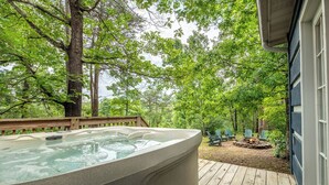 A hot tub on a wooden deck with a view of a forest. - *Spacious 5BD w/ Hot Tub | FirePit + Fireplaces* (Sevierville)