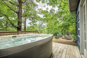 A hot tub on a wooden deck with a view of a forest. - *Spacious 5BD w/ Hot Tub | FirePit + Fireplaces* (Sevierville)