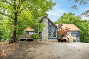 A two-story house with a stone facade, a wooden deck, and a covered porch. - *Spacious 5BD w/ Hot Tub | FirePit + Fireplaces* (Sevierville)