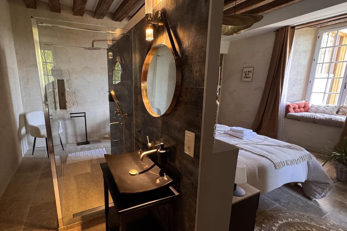 A bathroom with a modern sink, a large mirror, and a shower area.