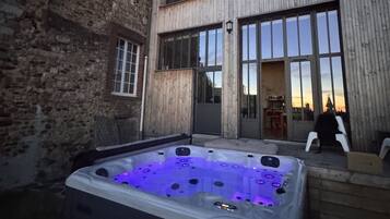 Un área de spa con un jacuzzi y un edificio de grandes ventanales.