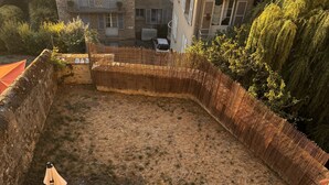A hot tub surrounded by stone walls and a wooden deck with lounge chairs. - Maison Saint Christophe (Le Mans)