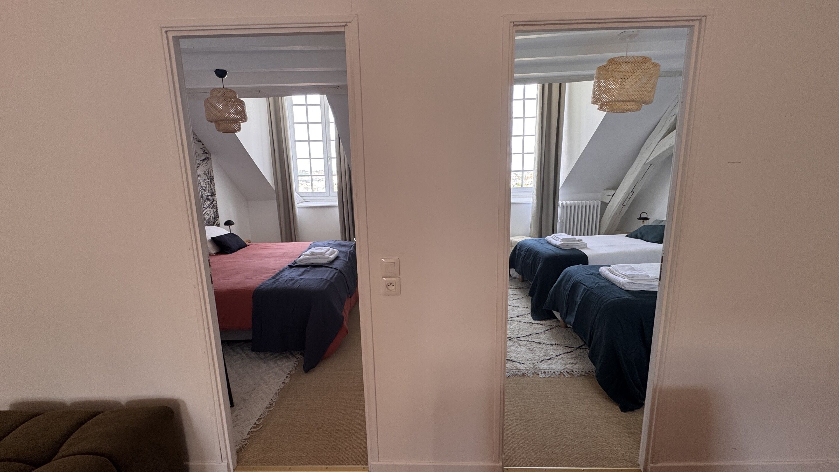 Ein Zimmer mit zwei Betten, einem Fenster und einem Deckenventilator.