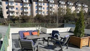 A rooftop patio with outdoor furniture, a table, and a planter. - Central loft with parking in Bergen (Bergen)