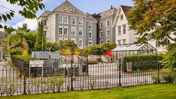 A multi-story building with a grey facade, large windows, and a gated entrance. - Cosy Apartment at Høyden with balcony (Bergen)