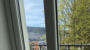 Ein Balkon mit Holzmöbeln und Blick auf eine Stadtlandschaft.