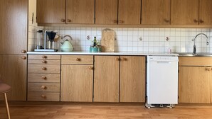 Eine Küche mit Holzschränken, einem weißen Geschirrspüler und einer gefliesten Spritzschutzwand.