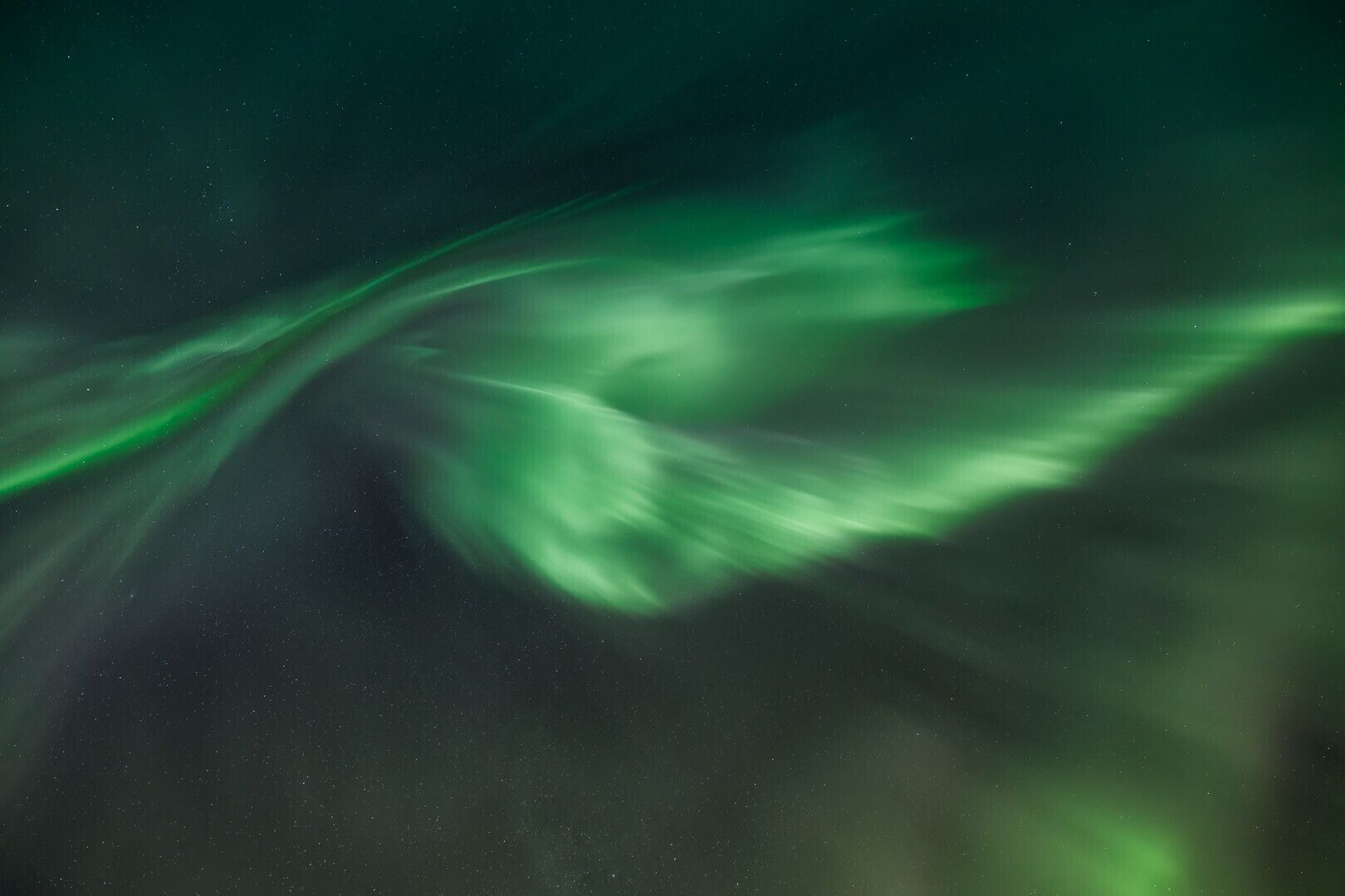 Een sterrenhemel met een groen poollicht.