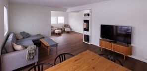 A modern living room with a sofa, ottomans, a wooden table, and a TV. - Fredly, beautiful home in Fredvang (Flakstad)