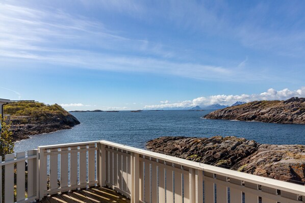 A coastal view with a wooden deck and rocky shoreline. - House in Henningsvær with amazing views (Vågan)