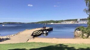 Una playa con un barco amarrado, una orilla arenosa y una vista despejada del agua.