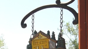 Un cartel con la palabra 'WELCOME', una ilustración de una casa y una cadena.