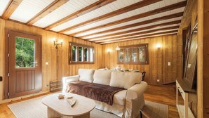 Un interior de madera con un sofá, una mesa y un televisor.