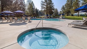 A swimming pool with lounge chairs and umbrellas, surrounded by trees. - New Listing! River Views | Hot Tub | Near Mt. Bachelor (Bend)