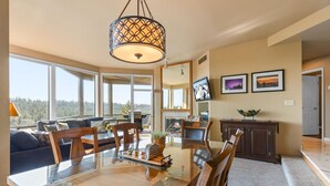 A spacious living area with a large dining table, comfortable seating, a fireplace, and a television. - New Listing! River Views | Hot Tub | Near Mt. Bachelor (Bend)