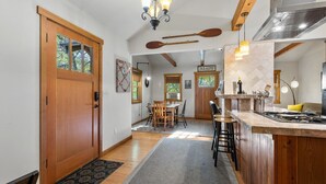 Eine Küche mit Holzausstattung, einer Bar und einem Essbereich mit Tisch und Stühlen.