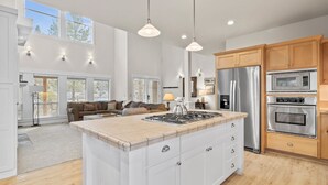 Una cocina moderna con una isla central, electrodomésticos de acero inoxidable y armarios de madera.
