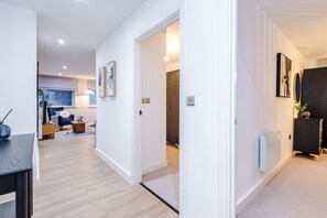 Un intérieur moderne avec un plancher en bois, des murs blancs et un meuble en bois foncé.